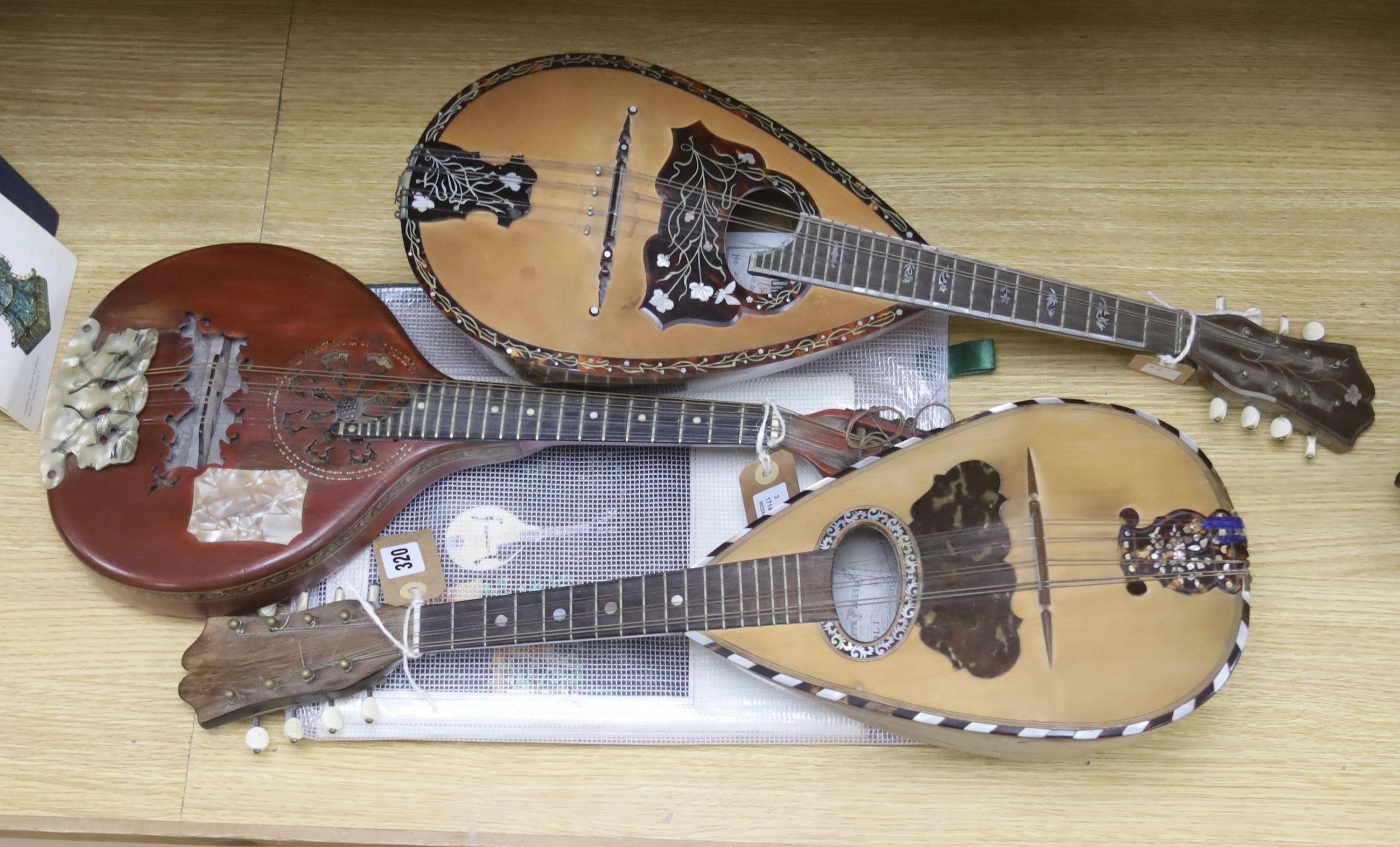 Three Neapolitan mandolins with inlaid mother of pearl decoration, one of round-backed form, the other two archtop